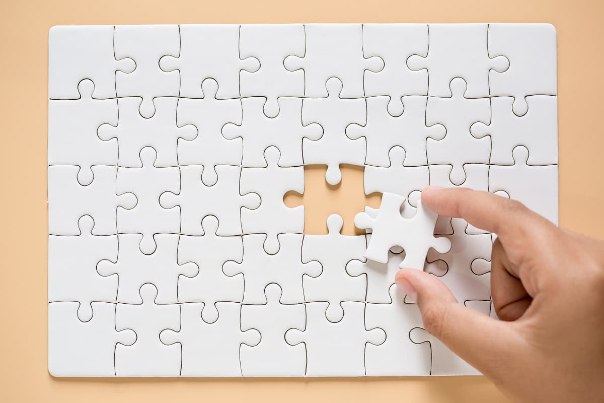 hand connecting puzzle pieces table background